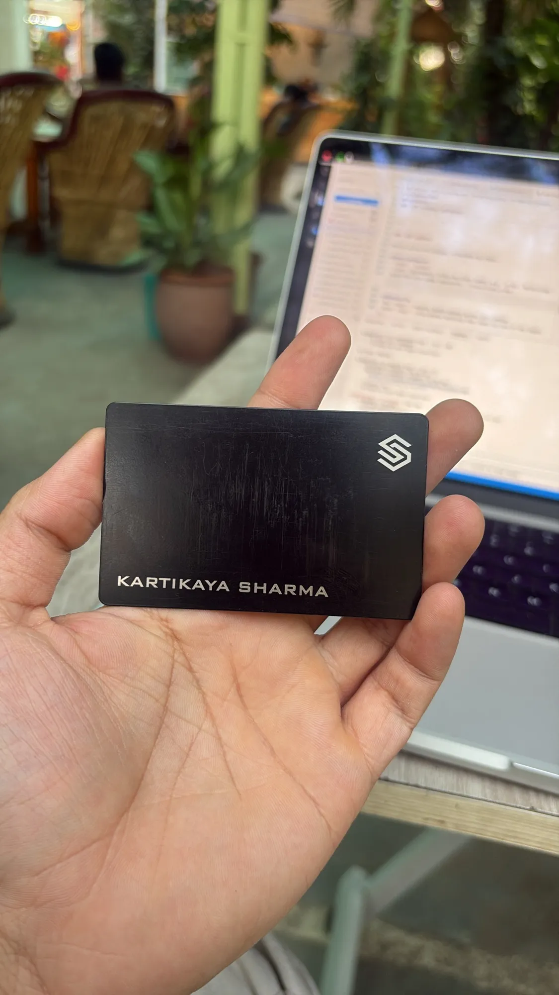 BLACKCARD smart business card held at a workspace desk